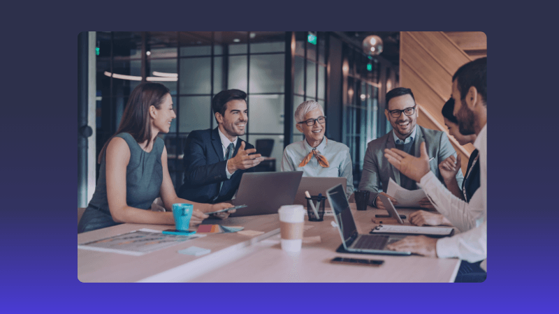 Diverse business professionals are engaged in a lively discussion at a modern office meeting.