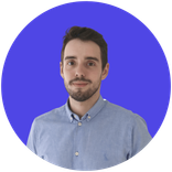 Portrait of a young man with dark hair and beard, wearing a blue shirt.