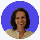 Smiling woman with dark hair wearing a light shirt, against a blue background.