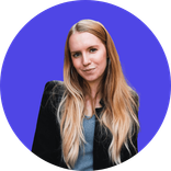 Blonde woman smiling at camera, wearing a dark jacket against a purple background.