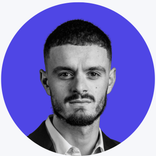 Headshot of a young man with short dark hair and a beard, in monochrome.