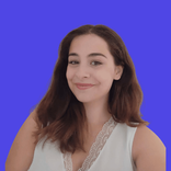 Smiling young woman with long dark hair wearing a white top against a blue background.