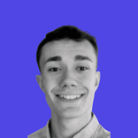 Smiling young man in black and white against a solid purple background.