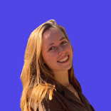 A young woman with long brown hair smiles broadly against a vibrant blue background.