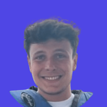 Headshot of a smiling young man with dark hair against a solid blue background.