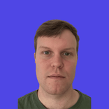 Headshot of a man with short brown hair and blue eyes, looking forward.