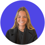 Smiling young woman with long blonde hair wearing black top and coat.