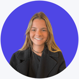 A smiling young woman with long blonde hair wearing a black jacket and top.