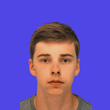 Headshot of a young man with short brown hair against a solid blue background.